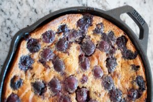 Cast iron skillet filled with cooked cherries and batter